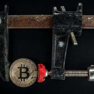 Conceptual image of cryptocurrency represented by a Bitcoin secured in a rusty clamp.